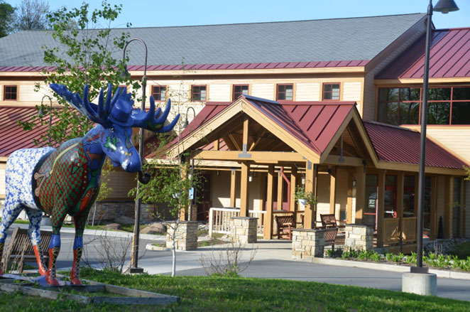 Large conference center building with a painted statue of a moose in front of it