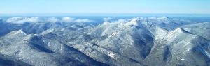 An aerial view of several snow covered mountain peaks
