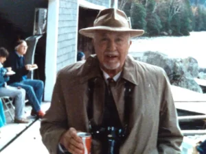 A man searing a suit, tie and rimmed hat smiling for the camera