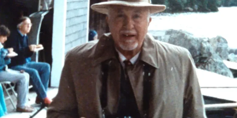 A man searing a suit, tie and rimmed hat smiling for the camera